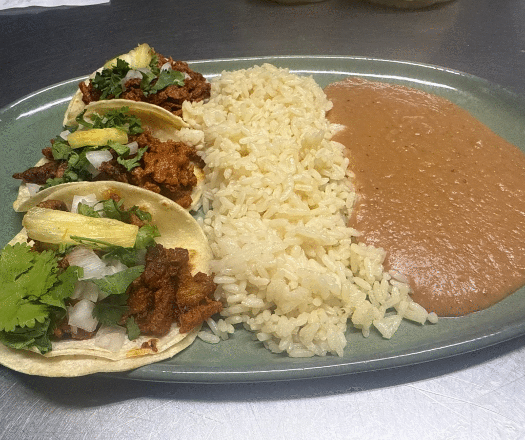 Three al pastor tacos with rice and beans